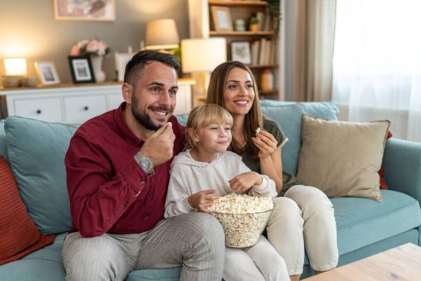Family enjoying popcorn and streaming movies on HolyIPTV service at home