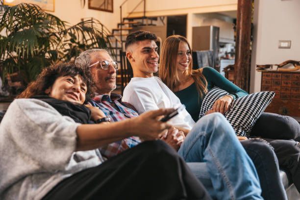 Happy family relaxing and watching IPTV Smarters Player content together on TV
