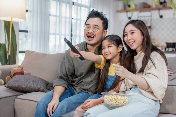 Young family watching IPTV together at home and enjoying their streaming service